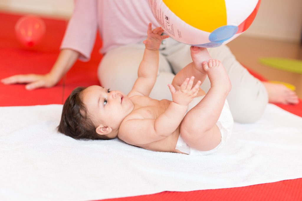 Baby spielt zusammen mit Kathartina Liebert mit einem Ball während eines Pekip-Kurses in Hamburg Eimsbüttel